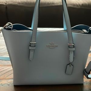 Small Coach purse can be cross body or hand purse. Light Blue color.